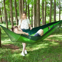 Casal relaxando na hammock com tela anti mosquito durante acampamento