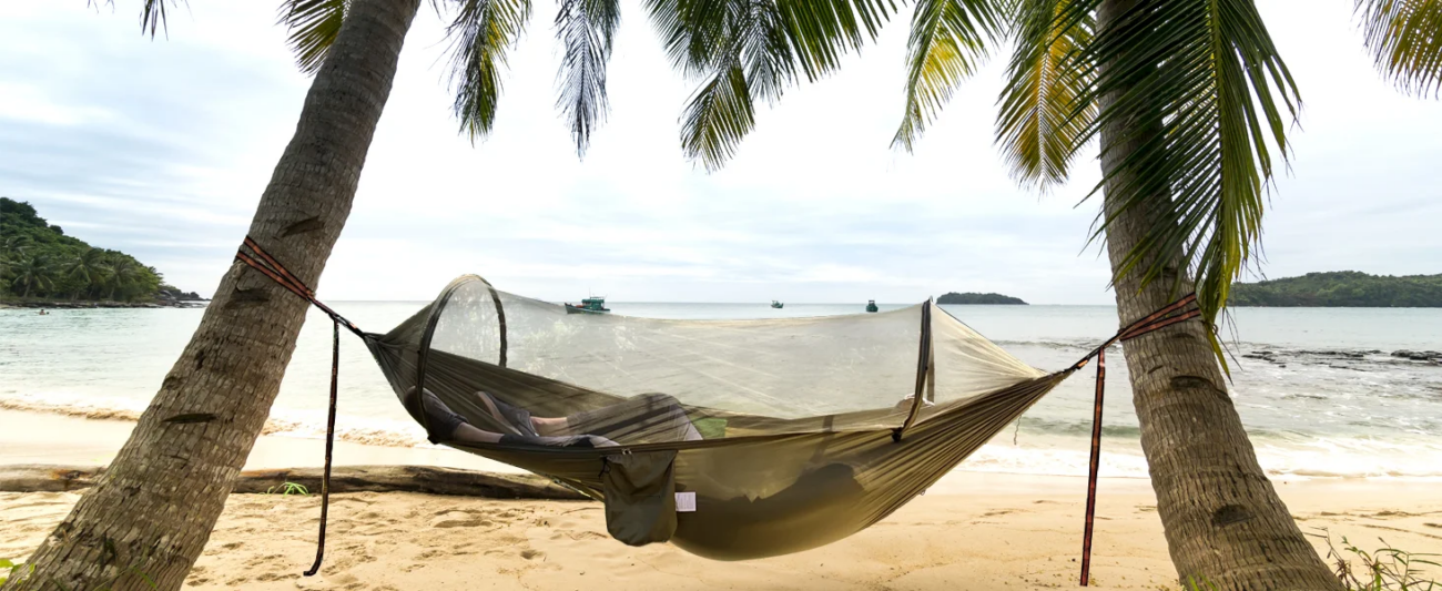 Hamaca de acampamento para 2 personas con mosquitera entre árboles en bosque