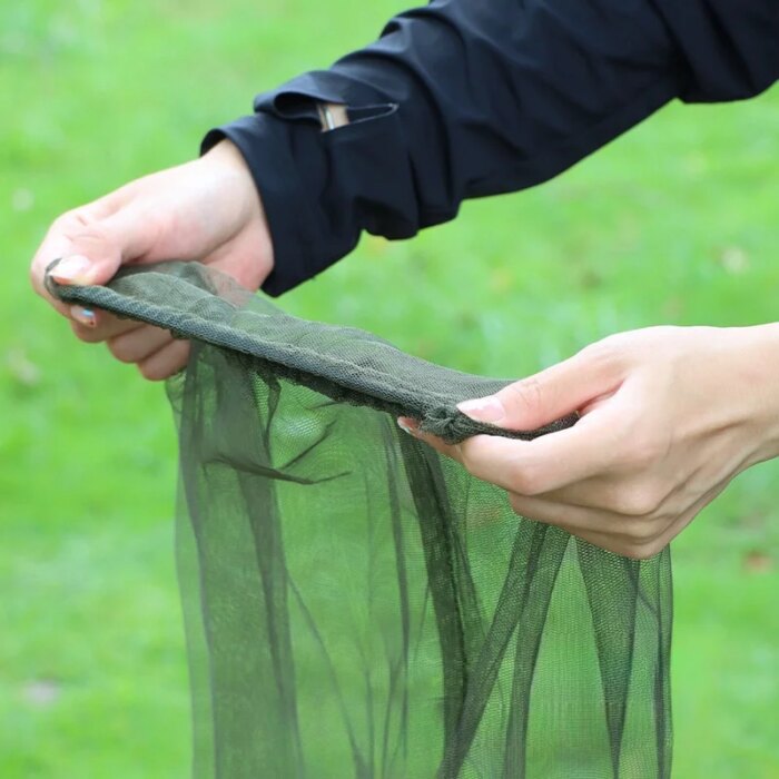 18933-v0dx5t.jpg Fishing enthusiast wearing a hat mosquito net during a river fishing trip