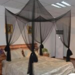 Familia usando o mosquiteiro em suíte com cama queen size