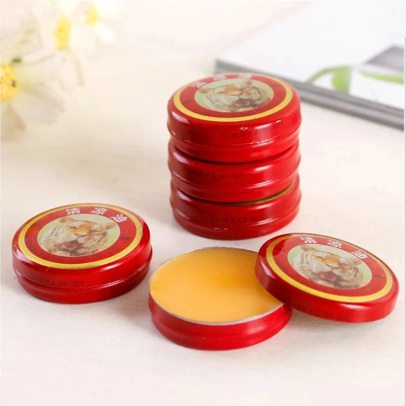 Aplicando pomada tiger balm en las sienes para alivio de dolor de cabeza